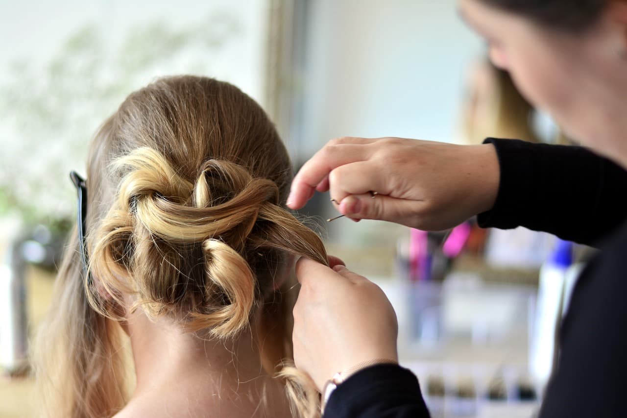 Stylist pinning a braided updo